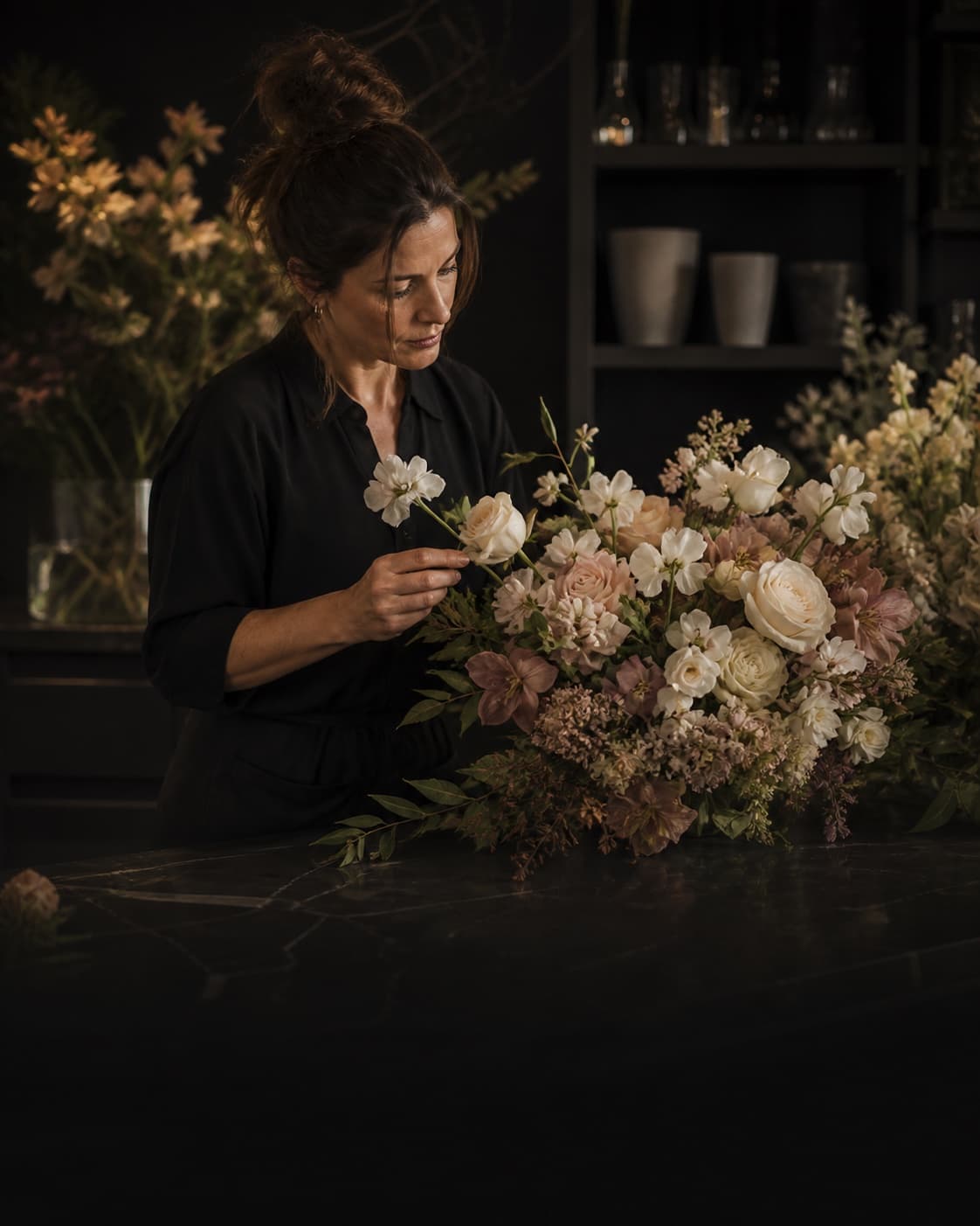 Eine Floristin arrangiert ein Premium-Bouquet in ihrem Atelier